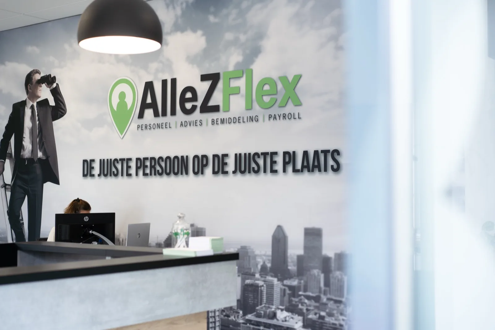 De balie van AlleZFlex met merkmuur